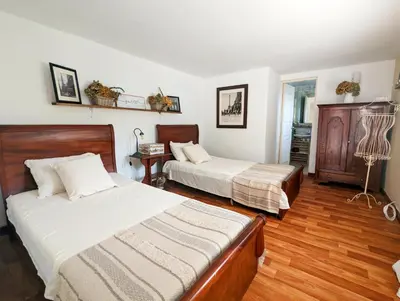 a bedroom with two beds and wooden floors at Hermosa Finca El Castillo - Excelente Ubicación Rionegro Marinilla in Rionegro