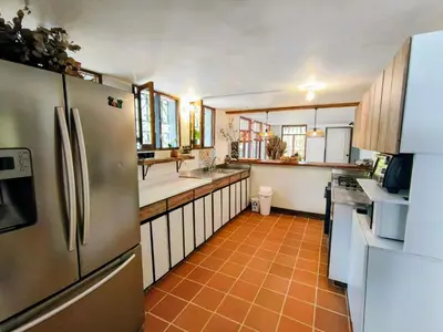 a kitchen with stainless steel appliances and orange tile floors at Hermosa Finca El Castillo - Excelente Ubicación Rionegro Marinilla in Rionegro