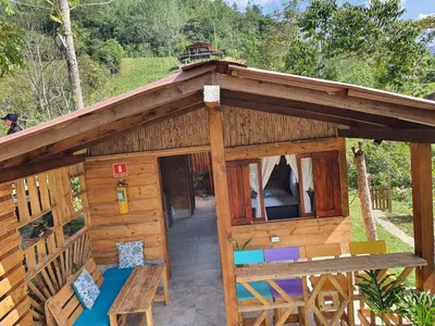 a large wooden house with a porch and a balcony at Cabañas la tierra prometida in Cisneros