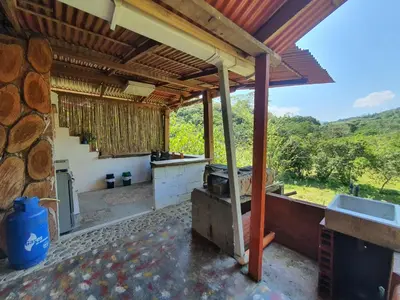 an outdoor kitchen with a view of a forest at Cabañas la tierra prometida in Cisneros