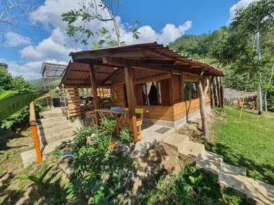 a small wooden house in a field at Cabañas la tierra prometida in Cisneros