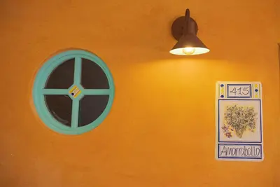 an orange wall with a blue window and a light at Alfahar Hotel in Carmen de Viboral