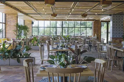 a dining room with tables and chairs and windows at Alfahar Hotel in Carmen de Viboral