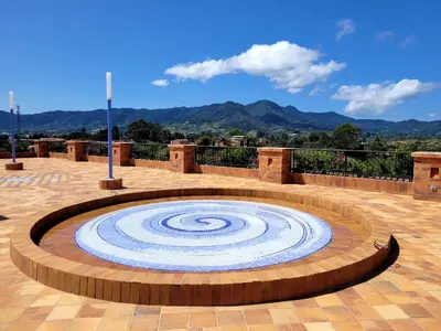 a large stone vortex in the middle of a patio at Alfahar Hotel in Carmen de Viboral