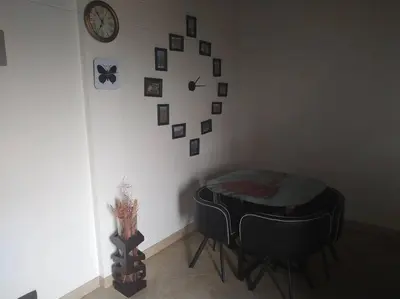a room with a table and a clock on the wall at Hermoso apartamento totalmente amoblado in Medellín