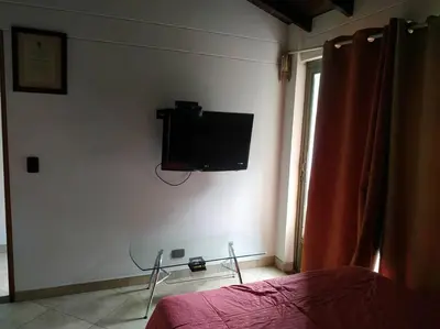 a bedroom with a bed and a tv on the wall at Hermoso apartamento totalmente amoblado in Medellín