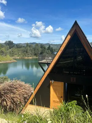 a house with a bridge over a river at GRETEL CHALETS SUIZO in Guatapé