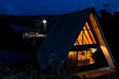 a house with a black roof at night at GRETEL CHALETS SUIZO in Guatapé