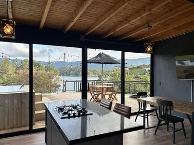 a kitchen and dining room with a view of the water at GRETEL CHALETS SUIZO in Guatapé