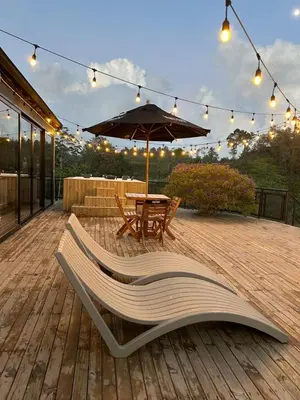 a wooden deck with a table and an umbrella at GRETEL CHALETS SUIZO in Guatapé