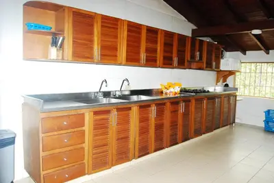a kitchen with wooden cabinets and a sink at Finca la Querendona in Santa Fe de Antioquia
