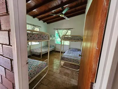 a room with three bunk beds in a house at Finca la Querendona in Santa Fe de Antioquia
