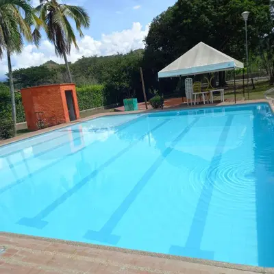 a large blue swimming pool with a gazebo at Finca la Querendona in Santa Fe de Antioquia