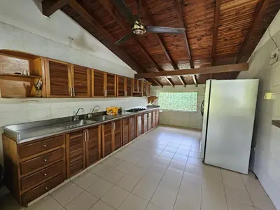 a kitchen with wooden cabinets and a refrigerator at Finca la Querendona in Santa Fe de Antioquia