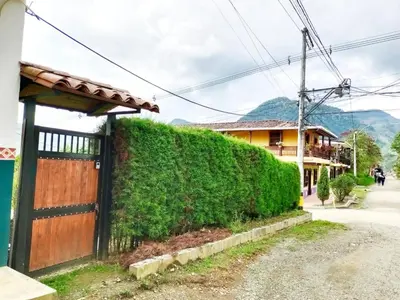 a hedge next to a house with a wooden gate at Bird House - Apartament in Jardin