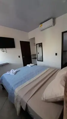 a bedroom with a large bed with a blue blanket at Katara Boutique Hotel in Mariquita