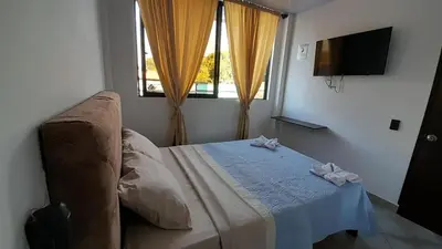 a bedroom with a bed with a table and a window at Katara Boutique Hotel in Mariquita