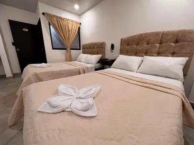 a hotel room with two beds with towels on them at Katara Boutique Hotel in Mariquita