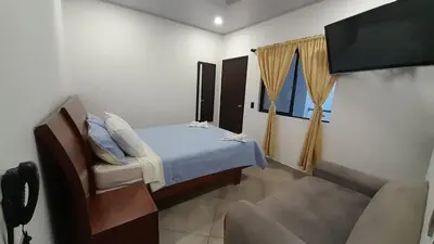 a bedroom with a bed and a tv and a couch at Katara Boutique Hotel in Mariquita