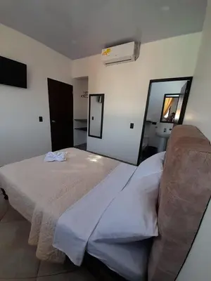 a bedroom with a large bed and a mirror at Katara Boutique Hotel in Mariquita
