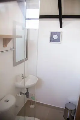 a white bathroom with a toilet and a sink at Apartamento amplio cerca al parque Guatape - Pajaros in Guatapé