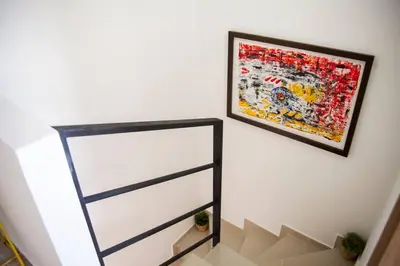 a painting hanging on a wall next to a staircase at Apartamento amplio cerca al parque Guatape - Pajaros in Guatapé