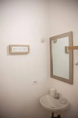 a white bathroom with a mirror and a sink at Apartamento amplio cerca al parque Guatape - Pajaros in Guatapé