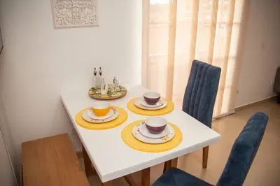 a white table with two cups and plates on it at Apartamento amplio cerca al parque Guatape - Pajaros in Guatapé