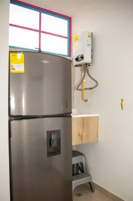 a stainless steel refrigerator in a kitchen with a window at Apartamento amplio cerca al parque Guatape - Pajaros in Guatapé