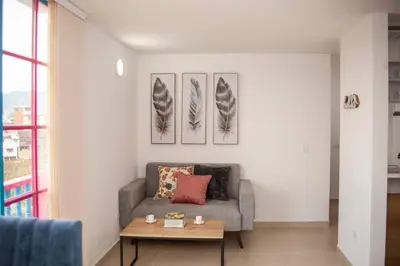 a living room with a couch and a table at Apartamento amplio cerca al parque Guatape - Pajaros in Guatapé