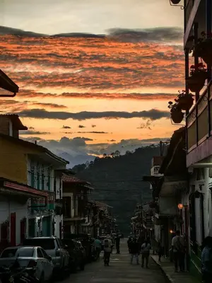a group of people walking down a street at sunset at Hotel Colonial in Jardin