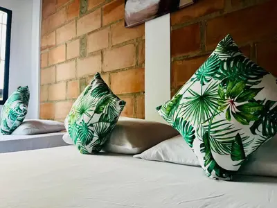 a bed with green and white pillows on it at HOTEL VILLA DANIELA in Puerto Triunfo