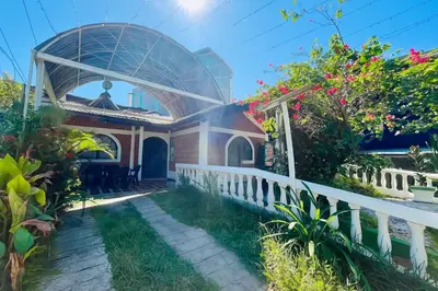 a house with a white fence and flowers at HOTEL VILLA DANIELA in Puerto Triunfo