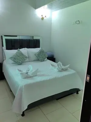 a white bed with white flowers on top of it at HOTEL VILLA DANIELA in Puerto Triunfo