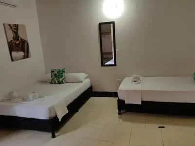 a room with two beds and a mirror at HOTEL VILLA DANIELA in Puerto Triunfo
