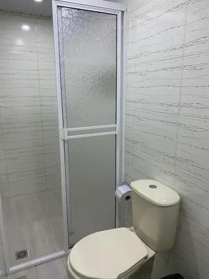 a white bathroom with a toilet and a shower at HOTEL VILLA DANIELA in Puerto Triunfo