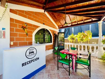 a restaurant with a red table and green chairs at HOTEL VILLA DANIELA in Puerto Triunfo