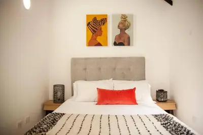 a bedroom with a bed with a red pillow at Cozy Apartment Rocks Guatape in Guatapé