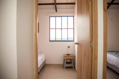 a room with two beds and a window at Cozy Apartment Rocks Guatape in Guatapé