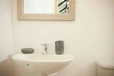 a bathroom with a white sink and a mirror at Cozy Apartment Rocks Guatape in Guatapé