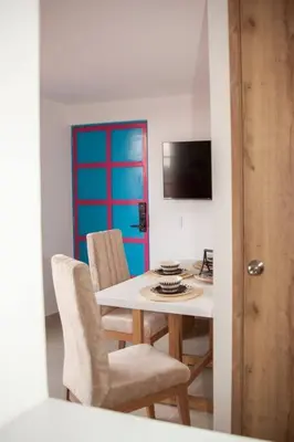 a dining room with a table and chairs and a blue door at Cozy Apartment Rocks Guatape in Guatapé