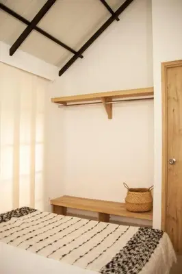 a bedroom with a bed and a basket on a table at Cozy Apartment Rocks Guatape in Guatapé