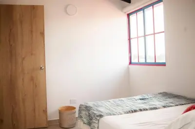a bedroom with a bed and a window at Cozy Apartment Rocks Guatape in Guatapé