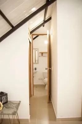 a hallway with a bathroom with a toilet and a table at Cozy Apartment Rocks Guatape in Guatapé