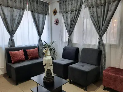 a living room with two chairs and a dog on a table at Espectacular apartamento primer piso capacidad 6 personas in Villamaría