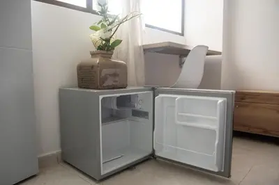 a small white refrigerator with a vase on top of it at Descansa en Habitación Privada en Medellín C in Medellín