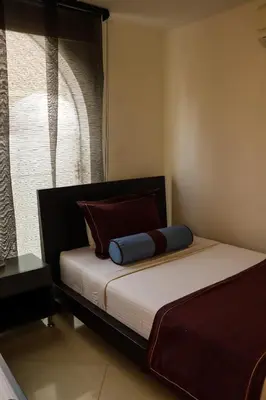 a bed with a blue pillow on it in a room at hotel medellin gold in Medellín