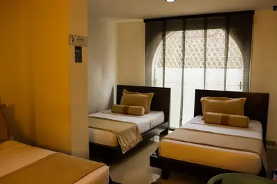 a room with two beds and a window at hotel medellin gold in Medellín