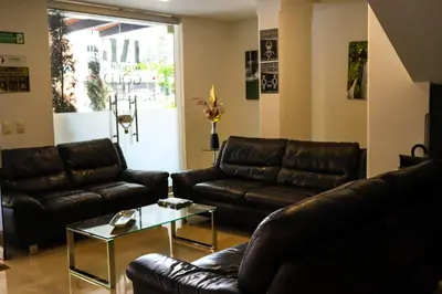 a living room with leather couches and a coffee table at hotel medellin gold in Medellín