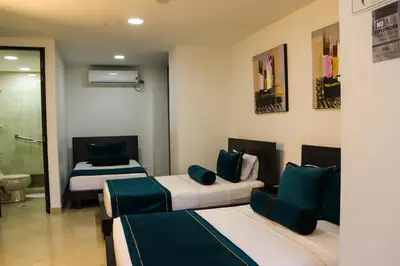 a hotel room with two beds and a bathroom at hotel medellin gold in Medellín